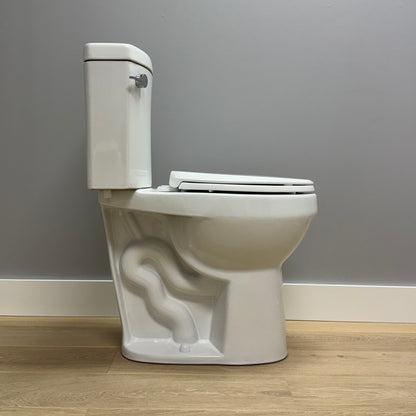 Side view of White toilet against a gray wall on a wooden floor